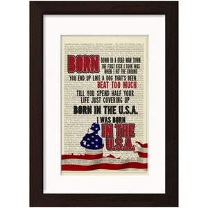 Könnte beinhalten: Ein Vintage-Druck der Songtexte zu "Born in the U.S.A." von Bruce Springsteen. Die Texte sind in Rot und Schwarz auf weißem Hintergrund gedruckt. Der Druck zeigt eine rot-weiß-blaue amerikanische Flagge.