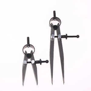 May include: Two dark grey metal wing dividers of different lengths, each featuring a circular top handle, two pointed legs, and a threaded adjustment screw with a small knob for precise spacing control, set against a plain white background.