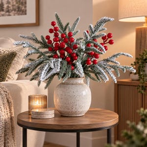 Peut inclure: Un arrangement décoratif de branches de pin artificielles avec une finition blanche givrée et des grappes de baies rouge vif. Les branches sont présentées dans un vase en céramique beige moucheté, doté d'une base et d'un col arrondis.