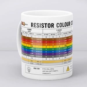 Op de afbeelding: Witte keramische mok met een weerstandskleurencodekaart. De mok heeft een handvat en bevat tekst zoals "RESISTOR COLOUR CODE" en "PRO TIP: If it's tiny, shiny and you can't read it... measure it."