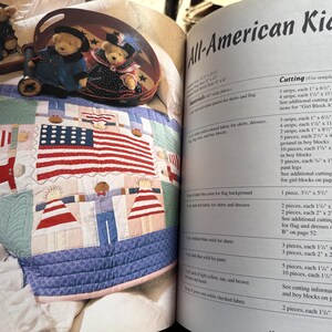 Op de afbeelding: Een knutselboekpagina getiteld All-American Kids met een quilt met een centraal Amerikaans vlagontwerp omringd door geappliqueerde figuren. De pagina bevat gedetailleerde snij-instructies en materiaallijsten voor de stoffen onderdelen.