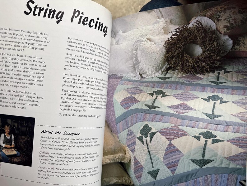 Op de afbeelding: Een boekpagina getiteld String Piecing met tekst over quilttechnieken en een biografie van de ontwerper, naast een doorgestikte sprei met een lichtblauw, paars en wit ruitpatroon met donkergroene bloemmotieven en een krans.
