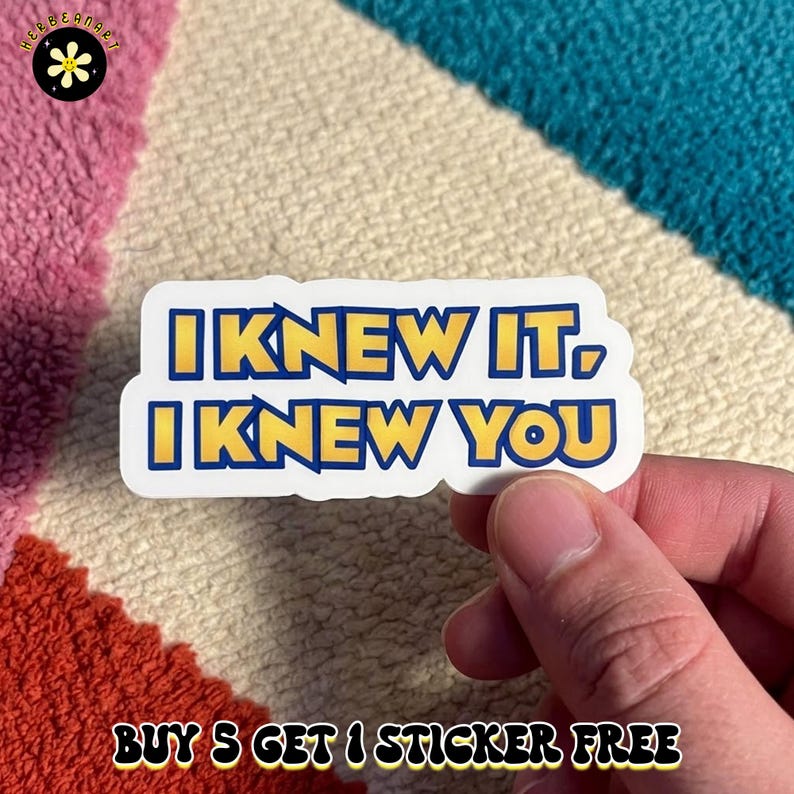 May include: A die-cut vinyl sticker featuring the text I KNEW IT, I KNEW YOU in bold yellow letters with a dark blue outline against a white background. The sticker has a smooth, matte finish and is shaped to follow the contour of the text.