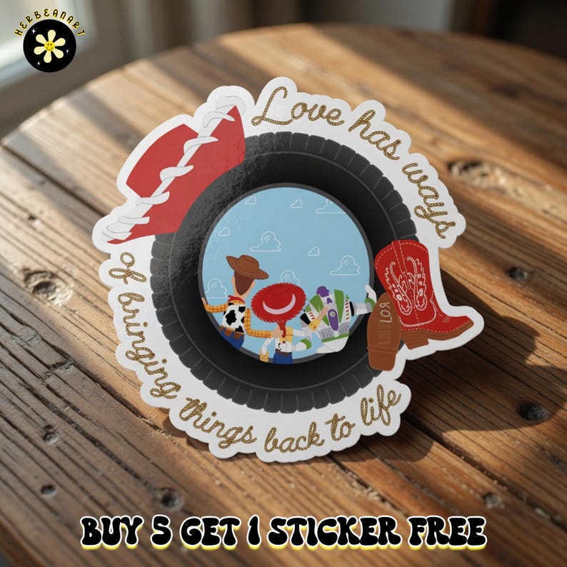 May include: A circular sticker featuring a black tire frame surrounding a blue sky scene with three cartoon characters. The design includes a red cowboy hat, a red cowboy boot, and the gold text Love has ways of bringing things back to life.