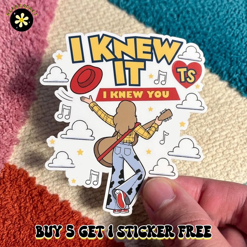 May include: A die-cut sticker featuring a person with long hair wearing a yellow plaid shirt and blue cow-print bell-bottom pants, holding an acoustic guitar. The text reads I KNEW IT and I KNEW YOU, surrounded by clouds, music notes, a red hat, and a red heart.