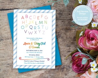 May include: A baby shower invitation with a rainbow-colored alphabet design. The invitation includes the names "Laura & Baby Girl O'Conner" and event details. The invitation is on a white background with blue stripes and a teal envelope.