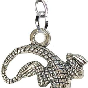 Op de afbeelding: Een zilverkleurige metalen bedel met een gedetailleerd hagedis- of gekko-ontwerp met een gestructureerd, geschubd oppervlak. De bedel is bevestigd aan een grote, cilindrische zilverkleurige hanger met een klein ringetje om vrij te hangen.