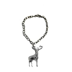 May include: A silver-coloured chain bracelet featuring a detailed stag pendant. The stag is shown standing with large antlers. The bracelet and pendant are set against a white background.