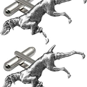 Pode incluir: Abotoaduras prateadas com um design detalhado de um cão em movimento. O cão é esculpido com detalhes realistas. As abotoaduras têm um acabamento polido e um design clássico. O design do cão repete-se em cada abotoadura.