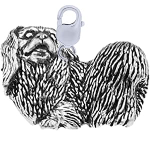 May include: A silver Pekingese dog charm with a lobster clasp. The charm features detailed fur texture and is designed to be attached to a bracelet or necklace. The dog is shown in a seated position.