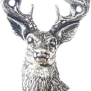 May include: A silver-toned metal brooch shaped like the head of a deer with detailed antlers. The surface features a textured finish that highlights the animal's fur and facial features, creating a realistic appearance for this decorative accessory.