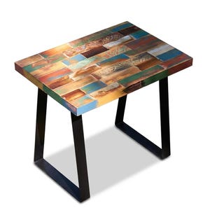 May include: A small, rectangular side table with a multi-colored, reclaimed wood top. The top is composed of various rectangular pieces in shades of blue, green, orange, and brown. The table has black metal legs, creating a modern, rustic aesthetic.