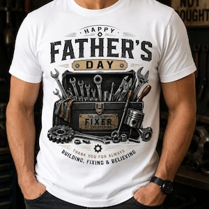 Può includere: Una t-shirt bianca con la grafica di una cassetta degli attrezzi nera piena di vari utensili in metallo. Il testo recita HAPPY FATHER'S DAY, THE ORIGINAL FIXER OF EVERYTHING e THANK YOU FOR ALWAYS BUILDING, FIXING & BELIEVING in nero e oro.