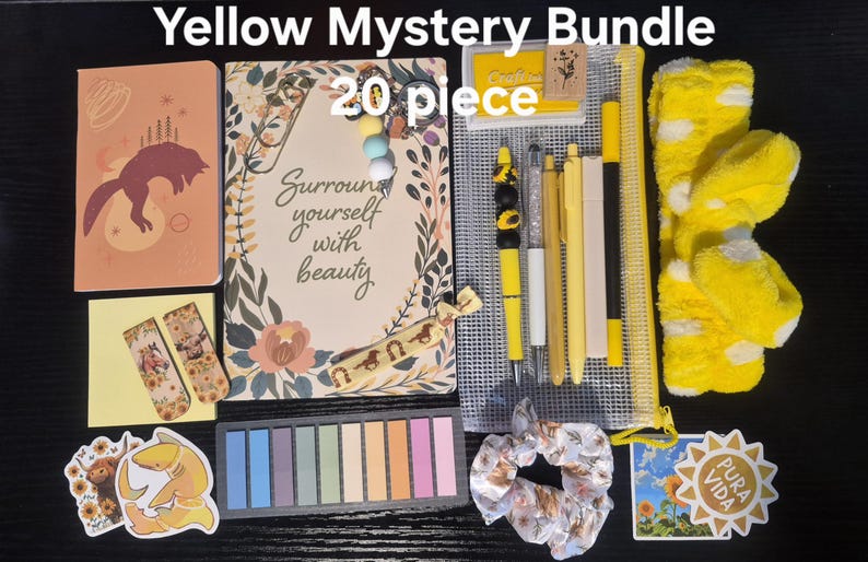 May include: A 20-piece Yellow Mystery Bundle containing a notebook with a fox illustration, a journal with the text "Surround yourself with beauty," a mesh pencil case, yellow pens, a yellow headband, sticky notes, stickers, and a scrunchie.