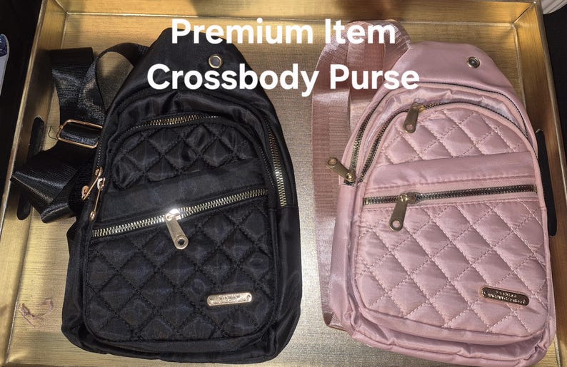 May include: Two crossbody bags, one black and one light pink, featuring a quilted diamond pattern, gold-tone metal zips, and adjustable straps. The text 'Premium Item Crossbody Purse' is displayed above the bags, which have a front pocket.