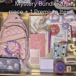 May include: A mystery bundle of 20 pieces plus 1 premium item in a gold tray. Includes a quilted pink backpack, a floral pouch, a beaded bracelet, a notebook, a pink pen, a tomato face mask, a hair headband, a hair clip, and various stationery.