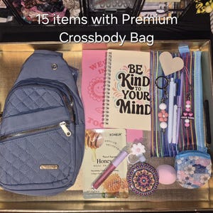 May include: A blue quilted crossbody bag with gold zips, a spiral notebook with the text BE KIND TO YOUR MIND, a striped pencil case, a honey face mask, a pink lip gloss, a floral compact mirror, a makeup sponge, and various keychains.