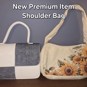 May include: Two bags with the text New Premium Item Shoulder Bag. The left bag is a structured handbag with a white and grey checkered pattern. The right bag is a cream-coloured shoulder bag with a vertical stripe pattern and a sunflower print.