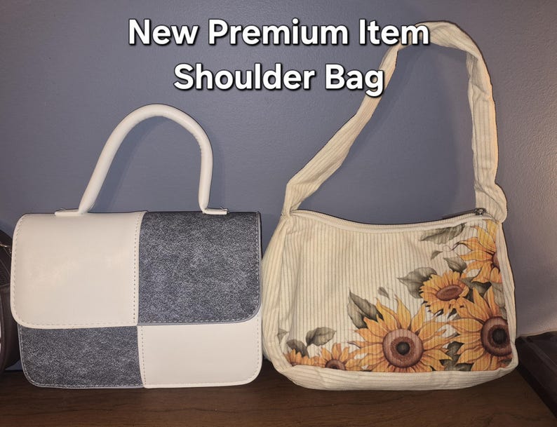 May include: Two bags with the text New Premium Item Shoulder Bag. The left bag is a structured handbag with a white and grey checkered pattern. The right bag is a cream-coloured shoulder bag with a vertical stripe pattern and a sunflower print.