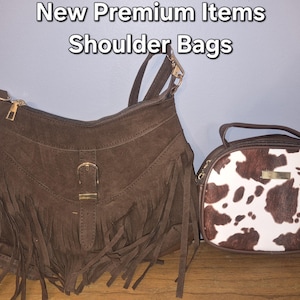 May include: Two shoulder bags with the text New Premium Items Shoulder Bags. The left bag is brown with fringe and a gold buckle. The right bag is oval-shaped with a brown and white cow print pattern and a gold-toned rectangular accent piece.