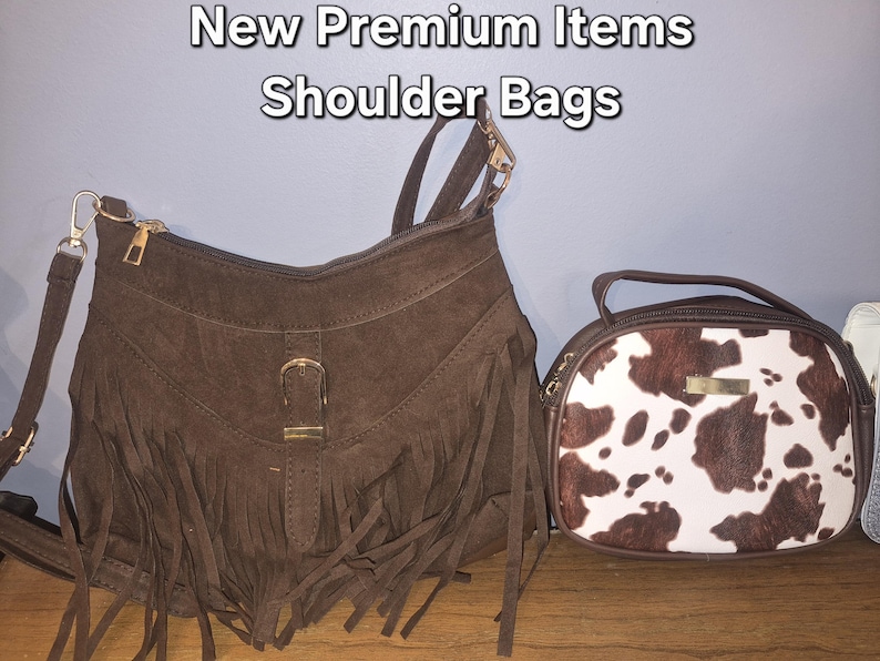 May include: Two shoulder bags with the text New Premium Items Shoulder Bags. The left bag is brown with fringe and a gold buckle. The right bag is oval-shaped with a brown and white cow print pattern and a gold-toned rectangular accent piece.