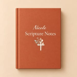 Op de afbeelding: Een notitieboek met harde kaft in gebrand oranje met de tekst Nicole Scripture Notes in het wit gedrukt. Onder de tekst staat een witte kruisafbeelding versierd met kleine, delicate bloemillustraties in gedempte groen- en rozetinten.