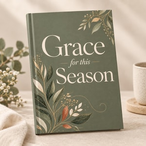 May include: A hardcover book with a sage green cover featuring the white text Grace for this Season. The cover is decorated with illustrations of delicate leaves and branches in shades of green, gold, and copper, arranged in the corners.