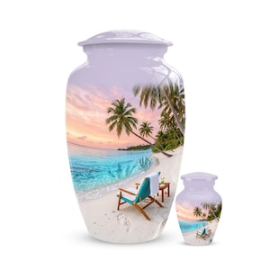 May include: A large and a small cremation urn, both featuring a wrap-around print of a tropical beach scene at sunset. The image displays white sand, turquoise ocean water, palm trees, a wooden lounge chair with a white towel, and a small table.