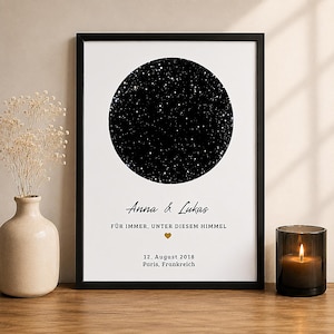 Könnte beinhalten: Ein gerahmter vertikaler Druck mit einer schwarzen, kreisförmigen Sternenkarte auf weißem Hintergrund. Der Text lautet Anna & Lukas, FÜR IMMER, UNTER DIESEM HIMMEL, 12. August 2018 und Paris, Frankreich, mit einem kleinen goldenen Herzsymbol.