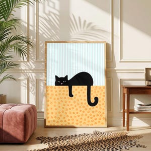 Pode incluir: Uma impressão de arte de parede retangular emoldurada apresentando um gato preto com nariz rosa descansando em uma linha horizontal. O fundo superior tem listras verticais azul-claras, enquanto a seção inferior é laranja com pequenos círculos amarelos.