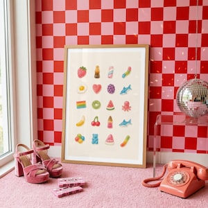 May include: A framed art print featuring a grid of colourful gummy candy illustrations on a cream background. The candies include a strawberry, cola bottle, fried egg, heart, grapes, shark, rainbow, donut, watermelon slice, octopus, banana, cherries, and bear.