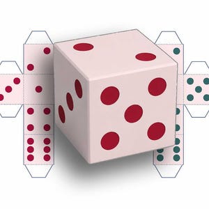 May include: A three-dimensional white cube die with red circular pips, positioned in front of a flat, unfolded paper template of a die featuring red and green circular pips on a light pink background with visible dashed fold lines.