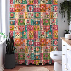 May include: A shower curtain featuring a repeating patchwork pattern of rectangular blocks. Each block displays colorful floral illustrations in shades of pink, orange, yellow, green, and teal, arranged in a grid across the entire fabric surface.