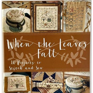 May include: A softcover book titled When the Leaves Fall: 10 Projects to Stitch and Sew by Blackbird Designs. The cover features a brown background with white text and six photographic insets displaying various cross-stitch and sewing projects.