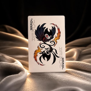 Black joker fantasy playing card featuring dark winged creature design with tribal inspired flame details