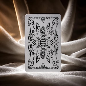 Decorative black and white card back design with ornate symmetrical fantasy artwork and vintage playing card style