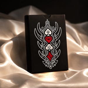 Luxury black playing card tuck box with gothic suit symbols and elegant fantasy card deck packaging design