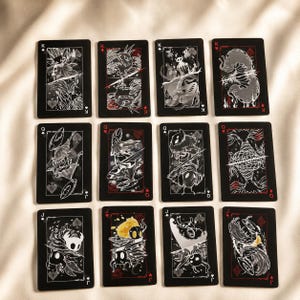 Fantasy playing card deck with black gothic design featuring illustrated creature face cards and luxury collector aesthetic