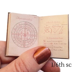 Pu&ograve; includere: Un piccolo libro aperto con illustrazioni in inchiostro rosso e nero. Il libro &egrave; intitolato "Mephistophilis Sigillum" e "Apokalyptic Sigillum". Il libro &egrave; in scala 1/6.