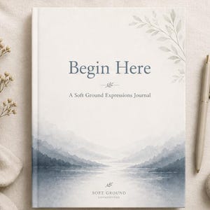 May include: A journal titled "Begin Here" with a watercolor landscape design. The cover features the text "Begin Here" and "A Soft Ground Expressions Journal." A pen and a small stone are next to the journal.