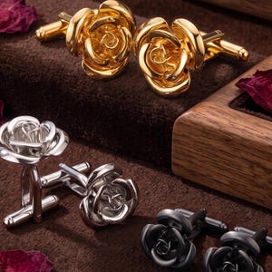 May include: Three pairs of rose-shaped cufflinks in polished gold, polished silver, and matte black finishes. Each pair features a detailed floral design with layered petals and a standard T-bar toggle closure mechanism on the back for secure fastening.