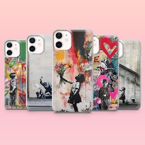 May include: Five clear smartphone cases arranged in a row, each featuring distinct street art designs. The designs include a child holding flowers, a figure with a hammer, a person in a suit, and various colourful graffiti-style patterns.