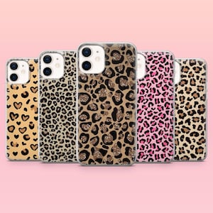 May include: A collection of five phone cases with various animal print designs. The cases feature patterns such as leopard spots, hearts, and glitter accents. The cases are in shades of brown, tan, pink, and gold, set against a pink background.