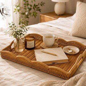 Pode incluir: Uma bandeja retangular de vime trançado com bordas recortadas contendo um vaso de vidro com flores brancas, uma vela marrom com o rótulo Relaxing Scent, uma caneca de cerâmica salpicada sobre um porta-copos, um caderno e uma caneta dourada.
