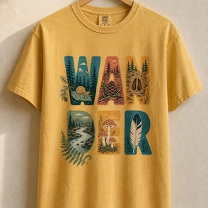 Camiseta con estampado de escenas de la naturaleza, camiseta de senderismo con letras ilustradas en el bosque, camiseta con estampado de piñas, setas y plumas. imagen 11