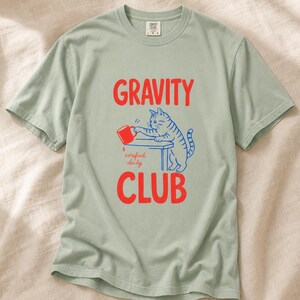 Gravity Club Cat T-Shirt Funny Cat Knocking Coffee Mug Off Table Tee Two Color Cat Lover Graphic Tee Gift imagem 5