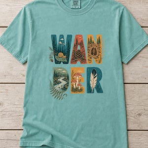 Camiseta con estampado de escenas de la naturaleza, camiseta de senderismo con letras ilustradas en el bosque, camiseta con estampado de piñas, setas y plumas. imagen 1