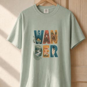 Camiseta con estampado de escenas de la naturaleza, camiseta de senderismo con letras ilustradas en el bosque, camiseta con estampado de piñas, setas y plumas. imagen 5