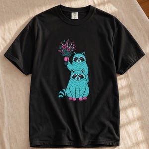 Two Raccoons Holding Wildflowers T-Shirt, Teal and Pink Riso Style Raccoon Tee, Cottagecore Animal Graphic Shirt, Soft Protest Gift image 1
