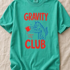 Gravity Club Cat T-Shirt Funny Cat Knocking Coffee Mug Off Table Tee Two Color Cat Lover Graphic Tee Gift imagem 14